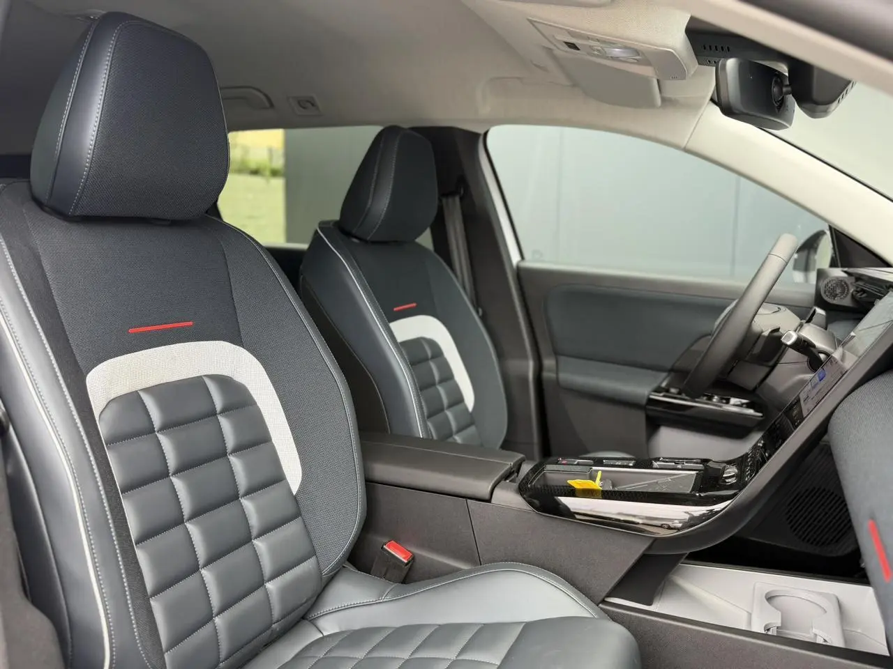 Vue intérieure côté conducteur du Citroën C5 Aircross 2026, sièges noirs avec inserts gris et détails rouges.