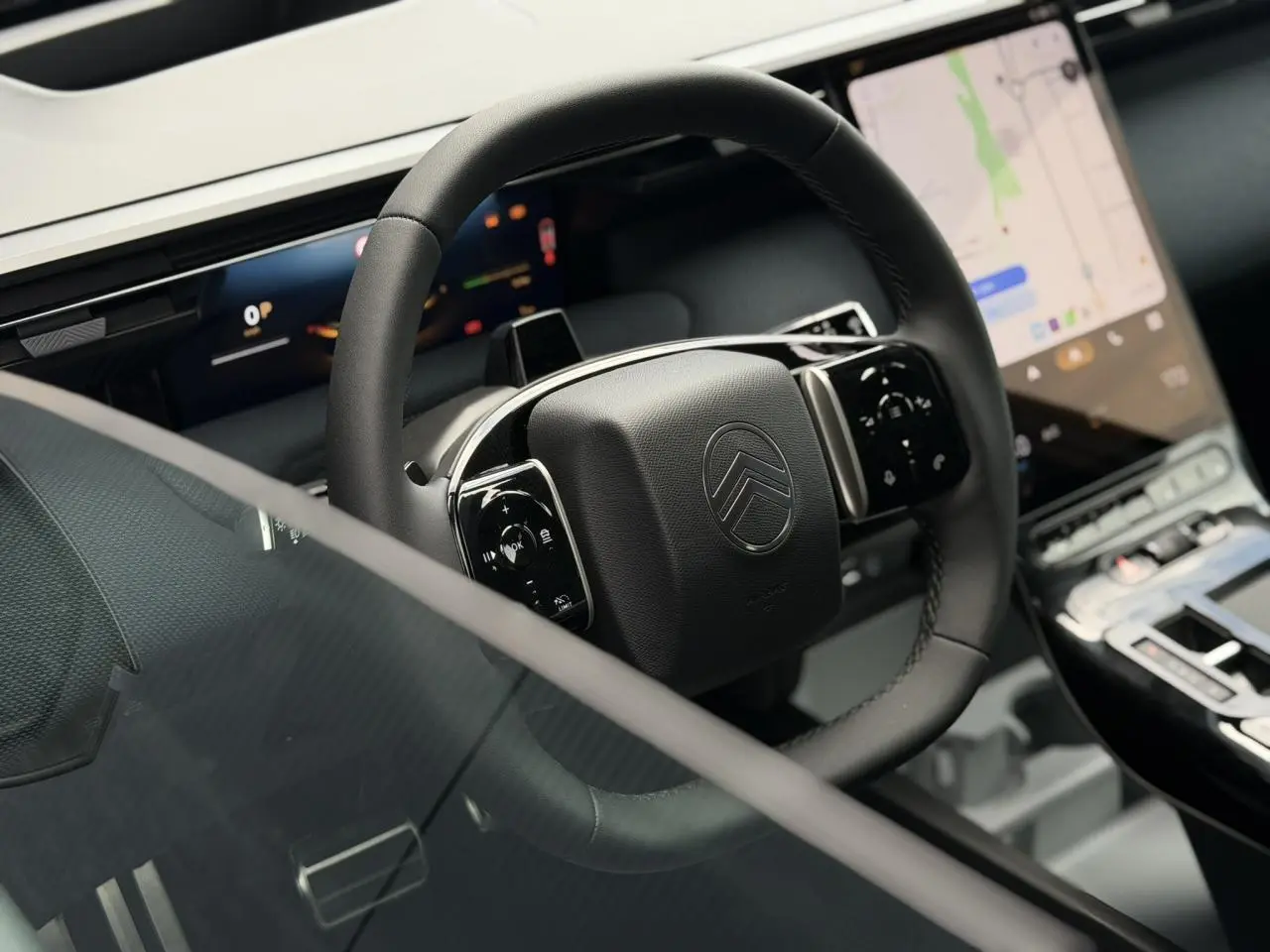 Vue rapprochée du volant noir multifonctions et de l’écran tactile vertical du tableau de bord du Citroën C5 Aircross 2026.