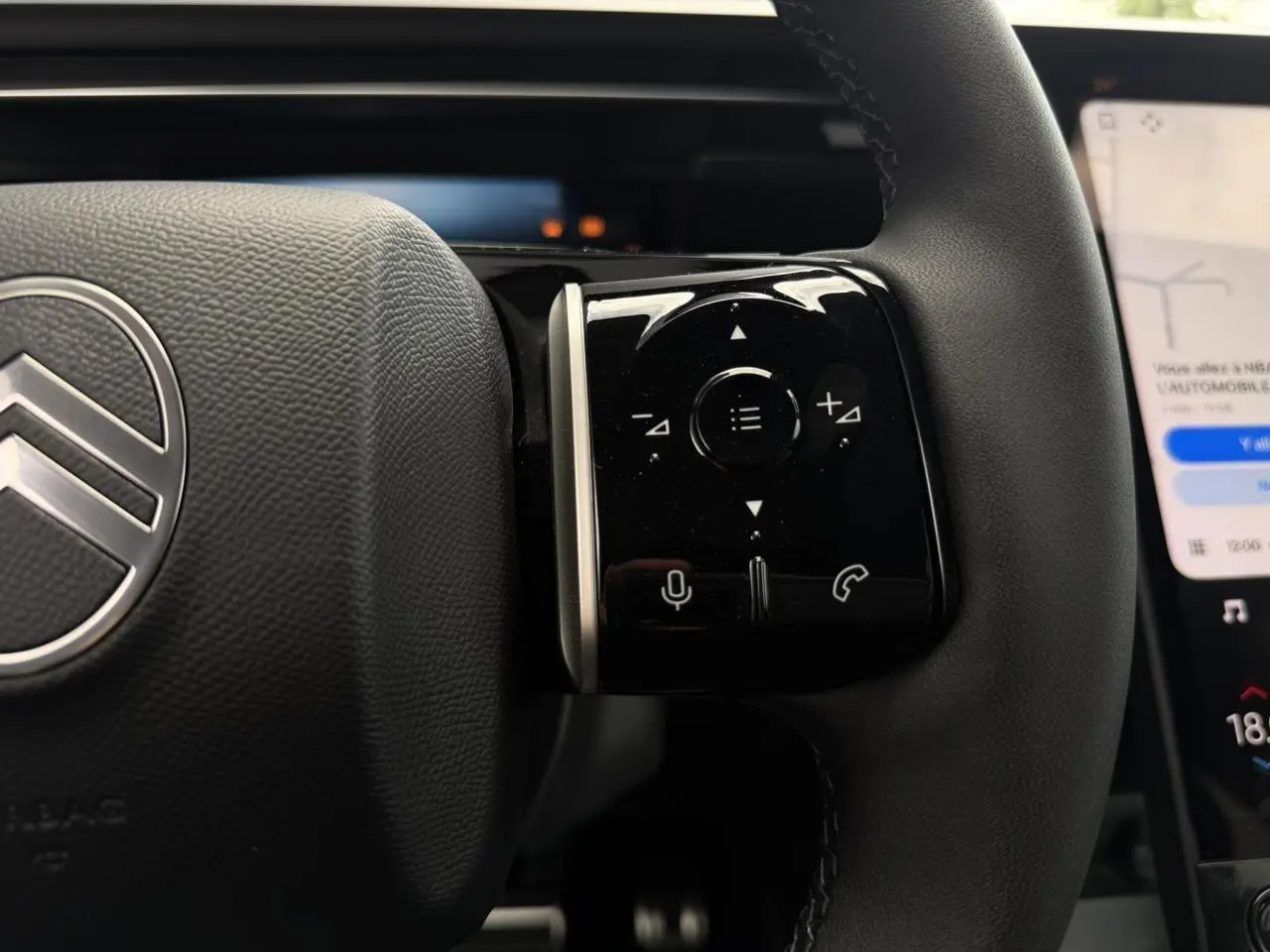 Gros plan sur le côté droit du volant noir du Citroën C5 Aircross 2026 avec commandes tactiles et logo argenté.