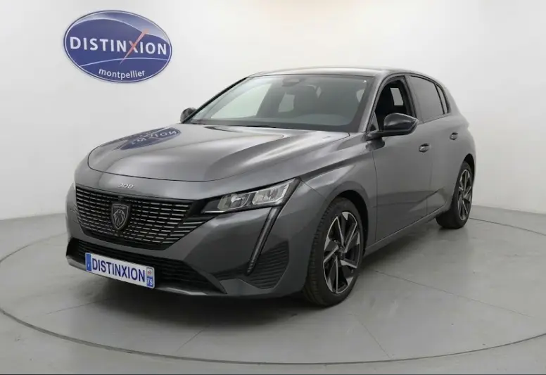 Peugeot 308 Hybrid gris vue 3/4 avant droit, jantes alliage 17 pouces et calandre noire distinctive.