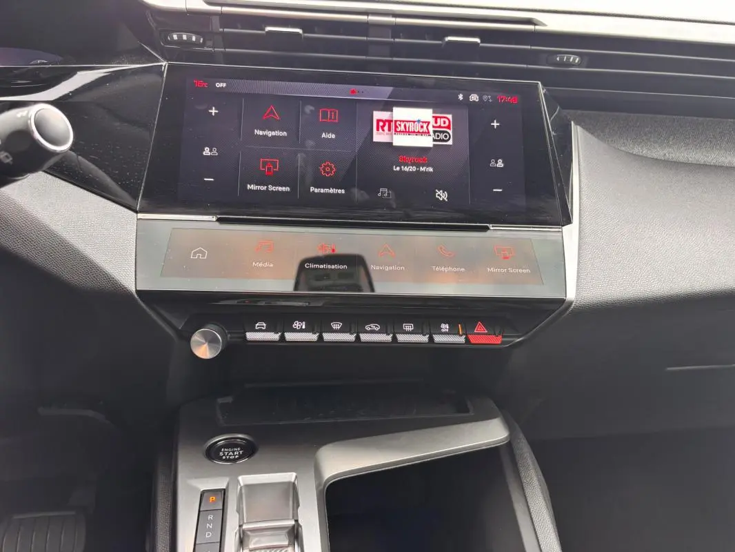 Vue intérieure du tableau de bord et console centrale de la Peugeot 308 Hybrid gris, avec écran tactile et commandes tactiles.