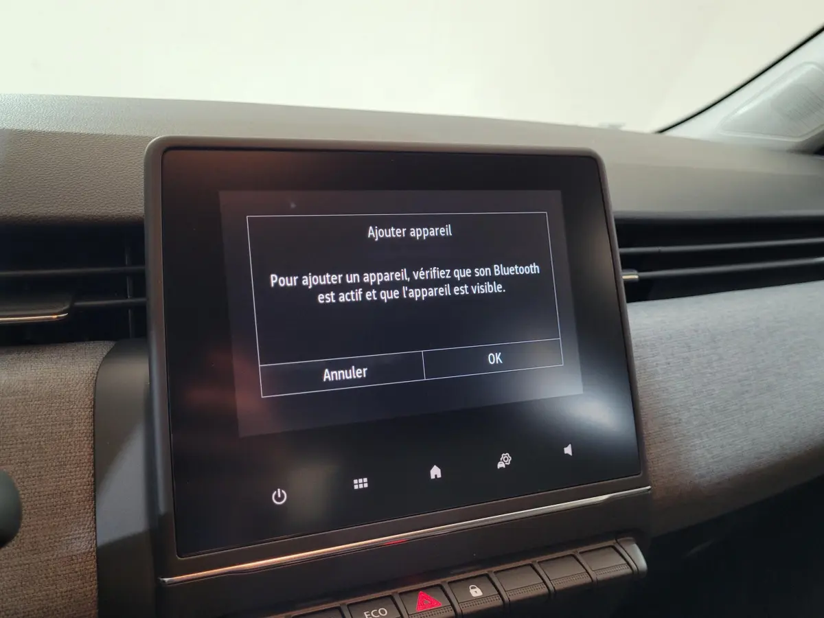 Écran tactile central affichant un message Bluetooth dans l'habitacle moderne d'une Renault Clio 2025.