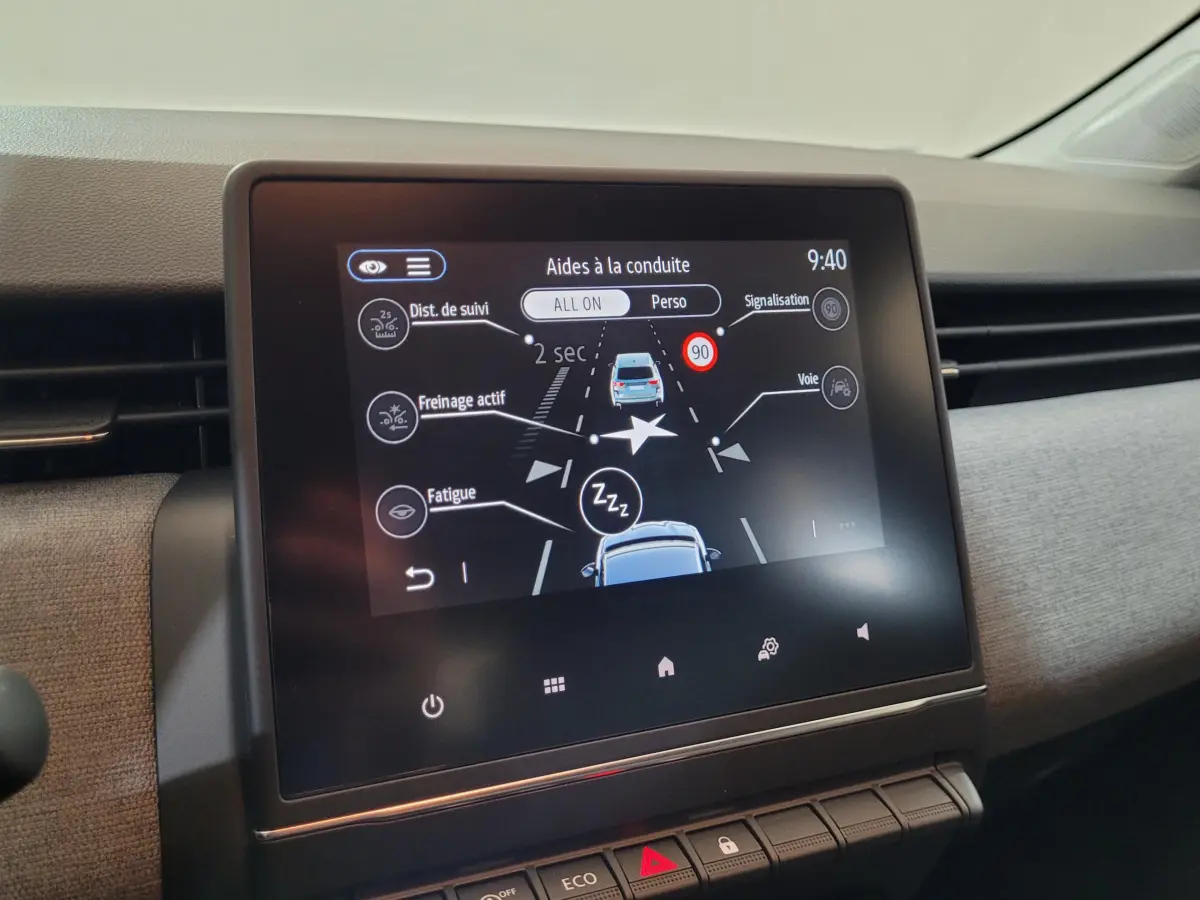 Écran tactile central du tableau de bord de la Renault Clio bleu 2025 montrant les aides à la conduite.