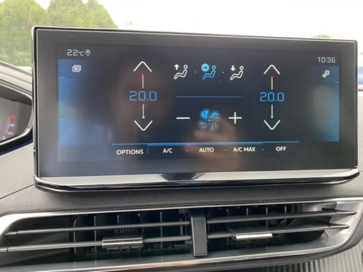 Écran tactile central du tableau de bord du Peugeot 3008 noir Perla Nera, affichant la climatisation à 20°C.