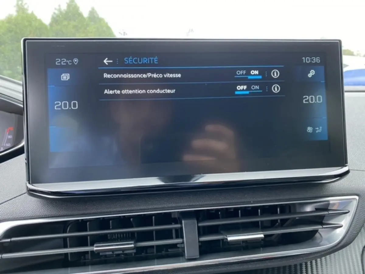 Écran tactile central du tableau de bord du Peugeot 3008 noir Perla Nera, affichant les réglages de sécurité et la climatisation.