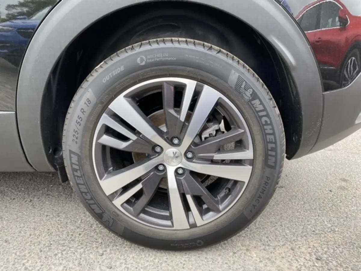 Gros plan sur la roue avant droite du Peugeot 3008 noir Perla Nera avec jante alliage et pneu Michelin.