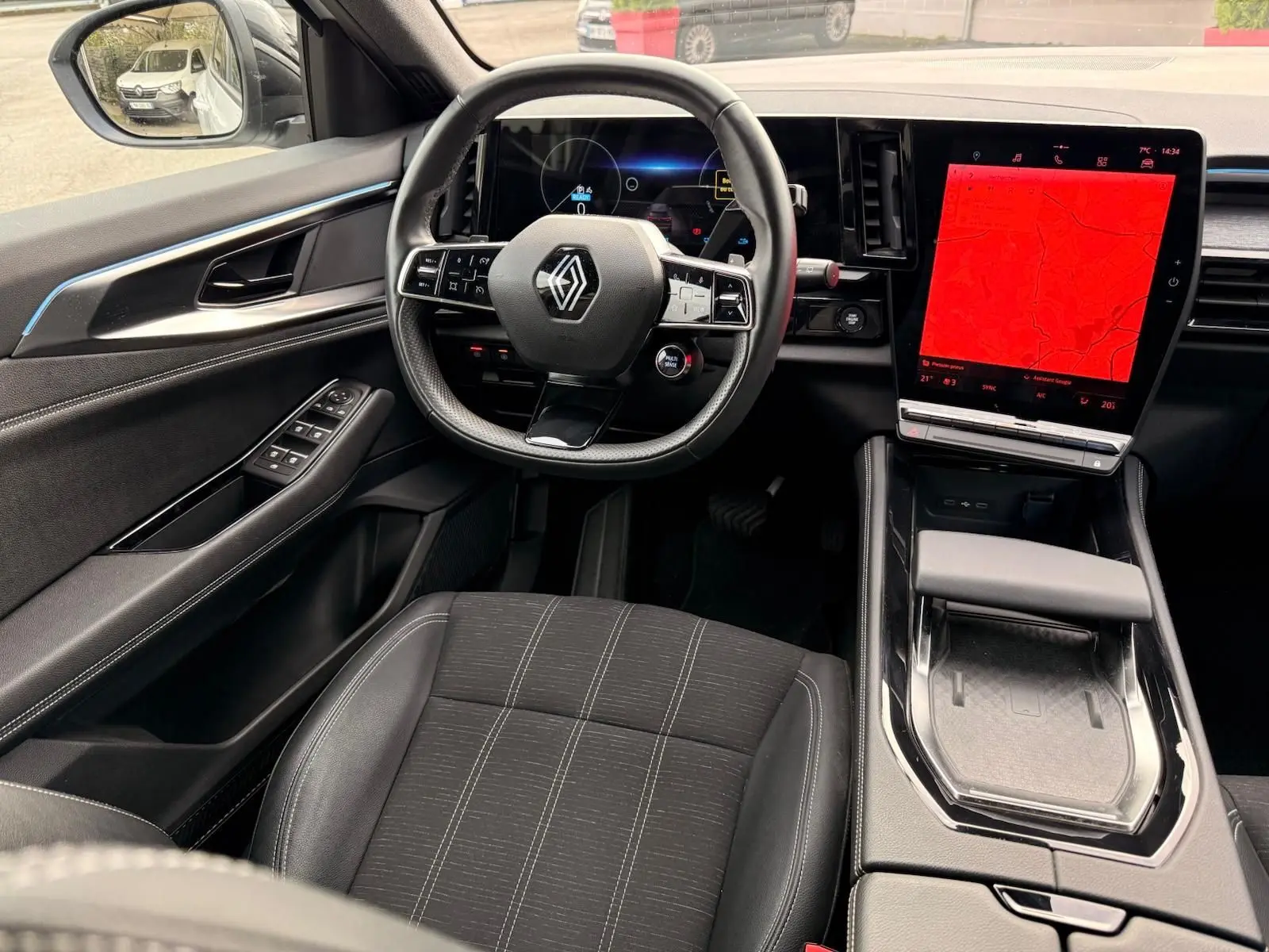 Intérieur Renault Austral E-Tech 200 hybride, vue côté conducteur sur volant, écran tactile vertical et sièges noirs.