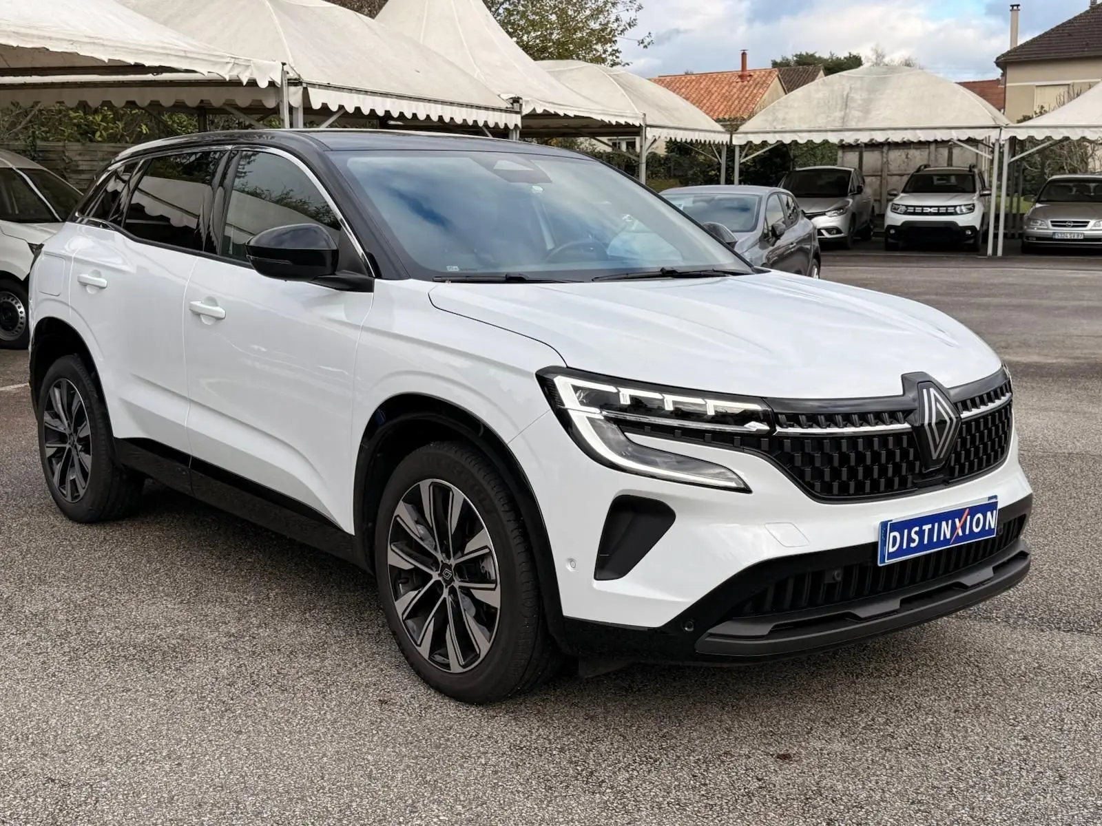 Renault Austral E-Tech 200 blanc nacré avec toit noir, vue 3/4 avant mettant en valeur la calandre et les jantes biton.