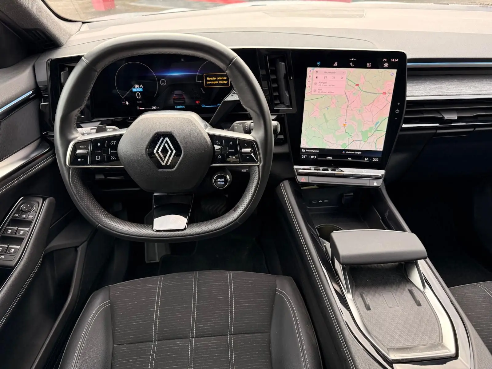 Vue intérieure du poste de conduite du Renault Austral E-Tech 200, avec volant multifonction et écran tactile central vertical.