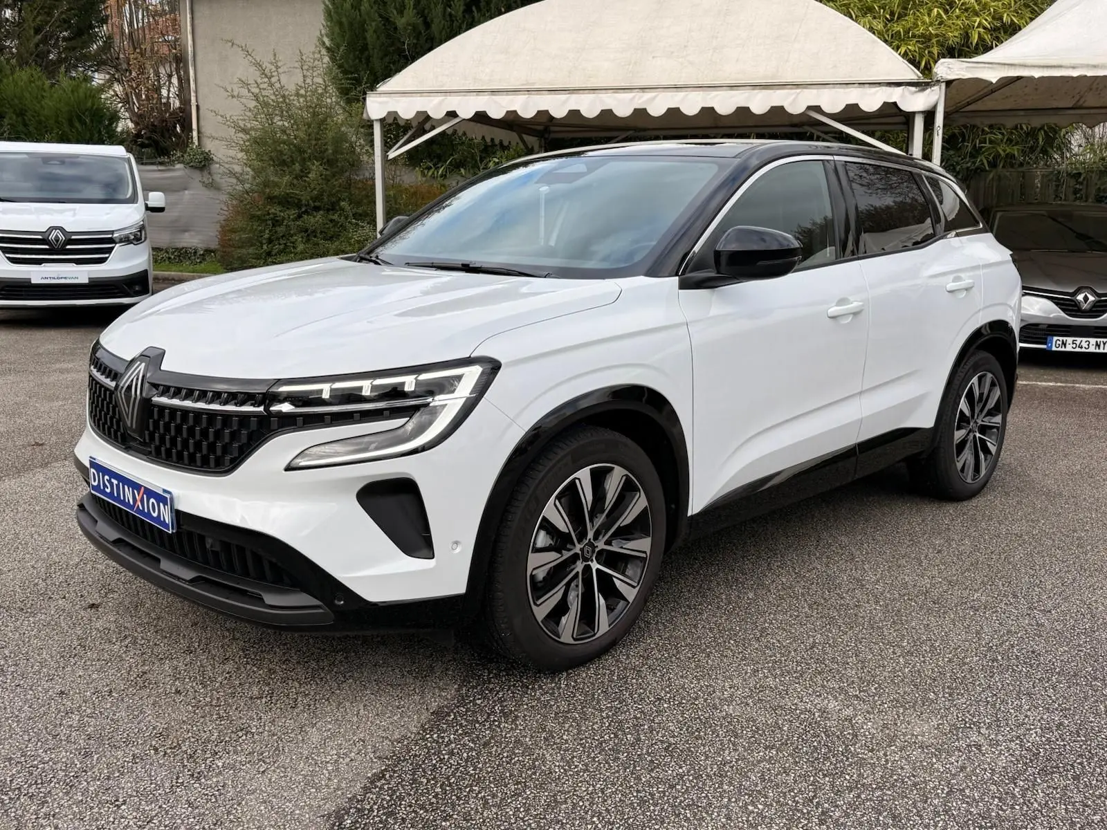 Renault Austral E-Tech 200 blanc nacré avec toit noir, vue 3/4 avant droit, jantes alliage bi-ton et calandre distinctive.