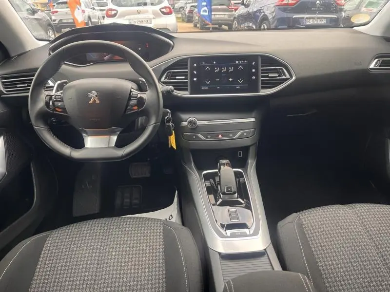 Vue intérieure avant du tableau de bord de la Peugeot 308 1.5 BlueHDi avec volant cuir multifonction et écran tactile central.