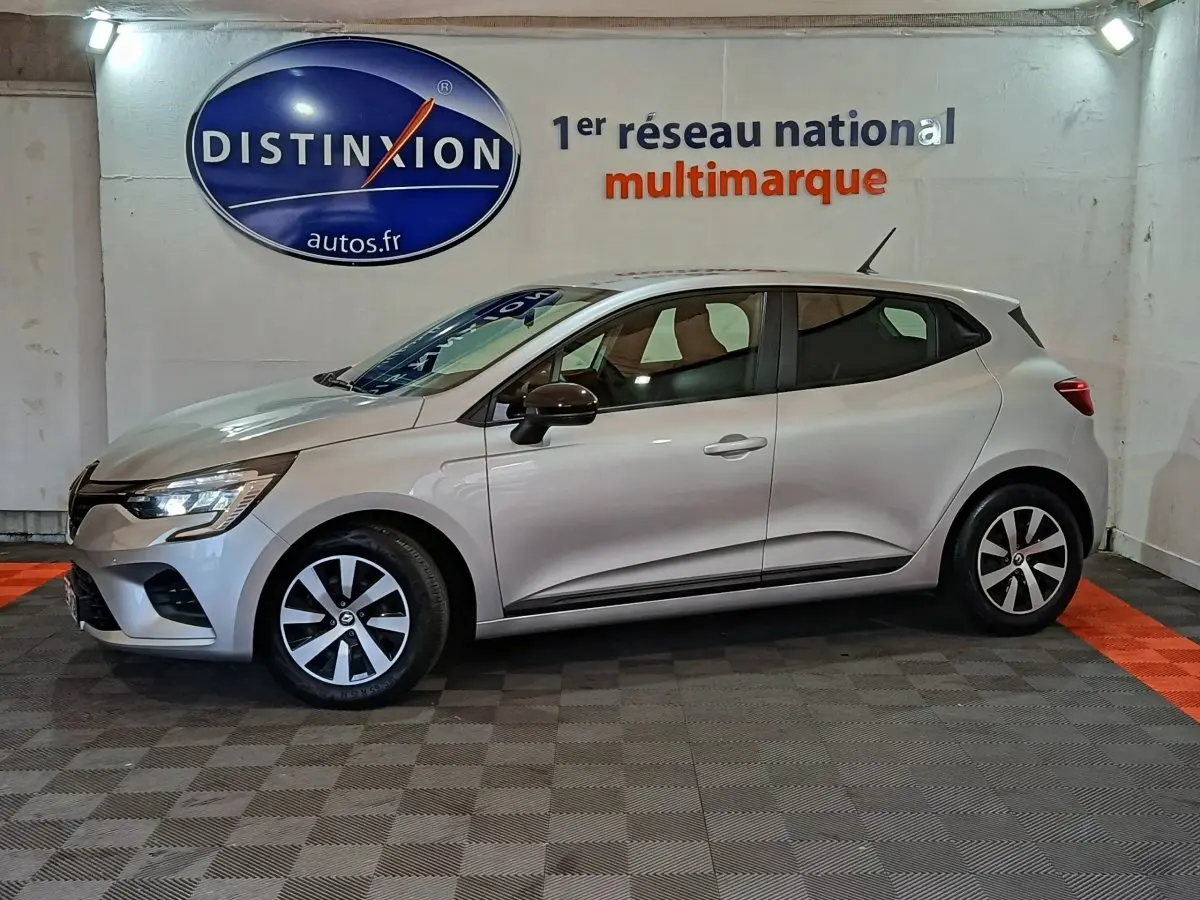 Renault Clio Equilibre TCe 90 gris clair vue de profil côté gauche, avec jantes alliage et feux LED allumés.