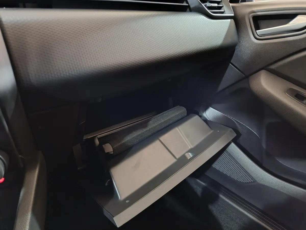 Vue intérieure côté passager de la boîte à gants ouverte dans une Renault Clio gris clair 2023.