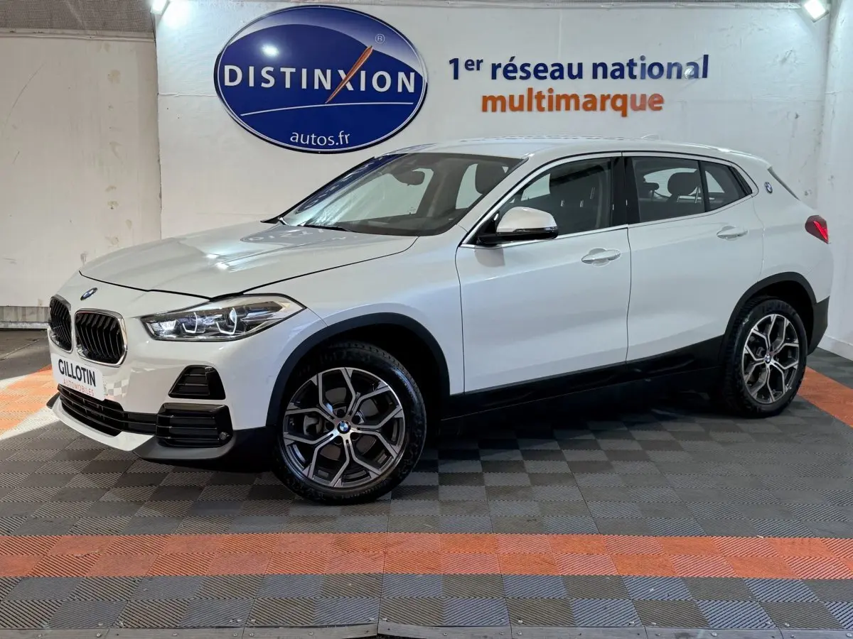 BMW X2 sDrive18i Lounge blanc en vue de profil côté gauche, avec jantes alliage et calandre caractéristique.