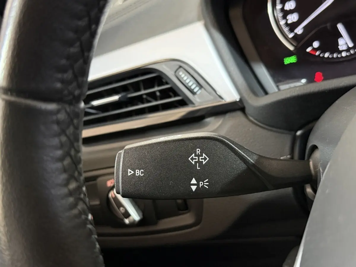 Gros plan sur la manette de clignotant noire dans l'habitacle du BMW X2 sDrive18i Lounge 2023.