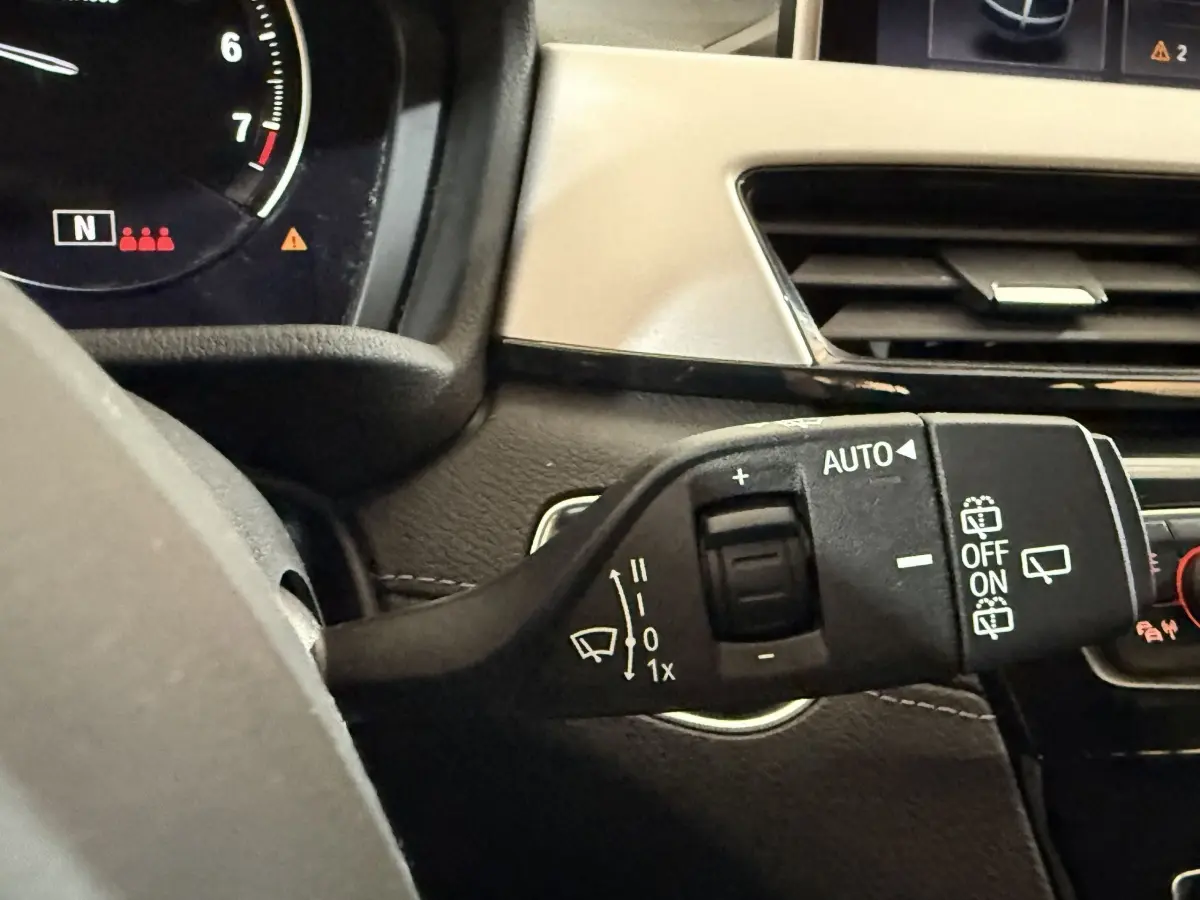 Gros plan sur la commande d’essuie-glace côté droit du tableau de bord intérieur d’une BMW X2 blanche 2023.