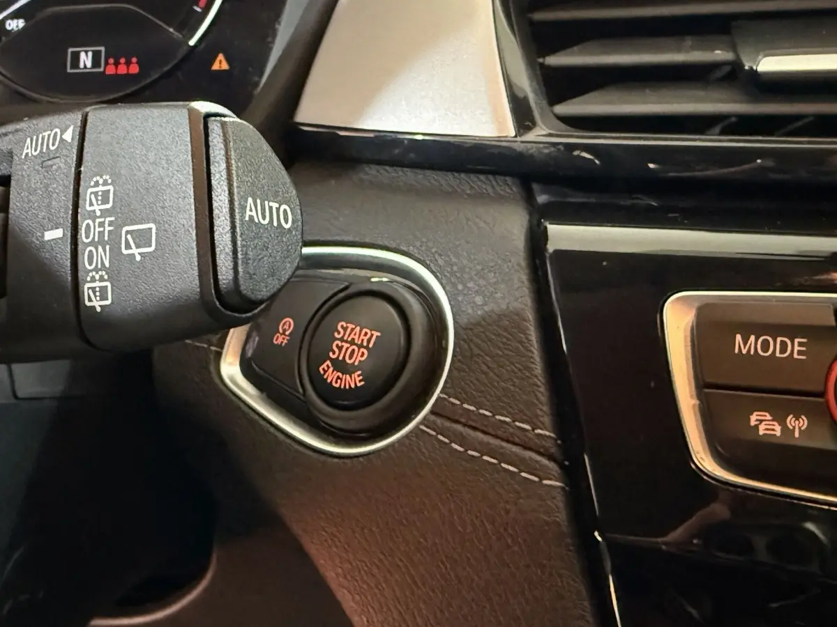 Gros plan sur le bouton Start Stop Engine rouge dans l’habitacle noir et beige du BMW X2 sDrive18i Lounge 2023.