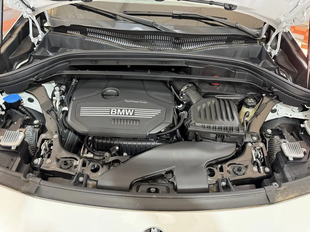 Moteur TwinPower Turbo BMW visible sous le capot ouvert d’un BMW X2 blanc, vue de face rapprochée.