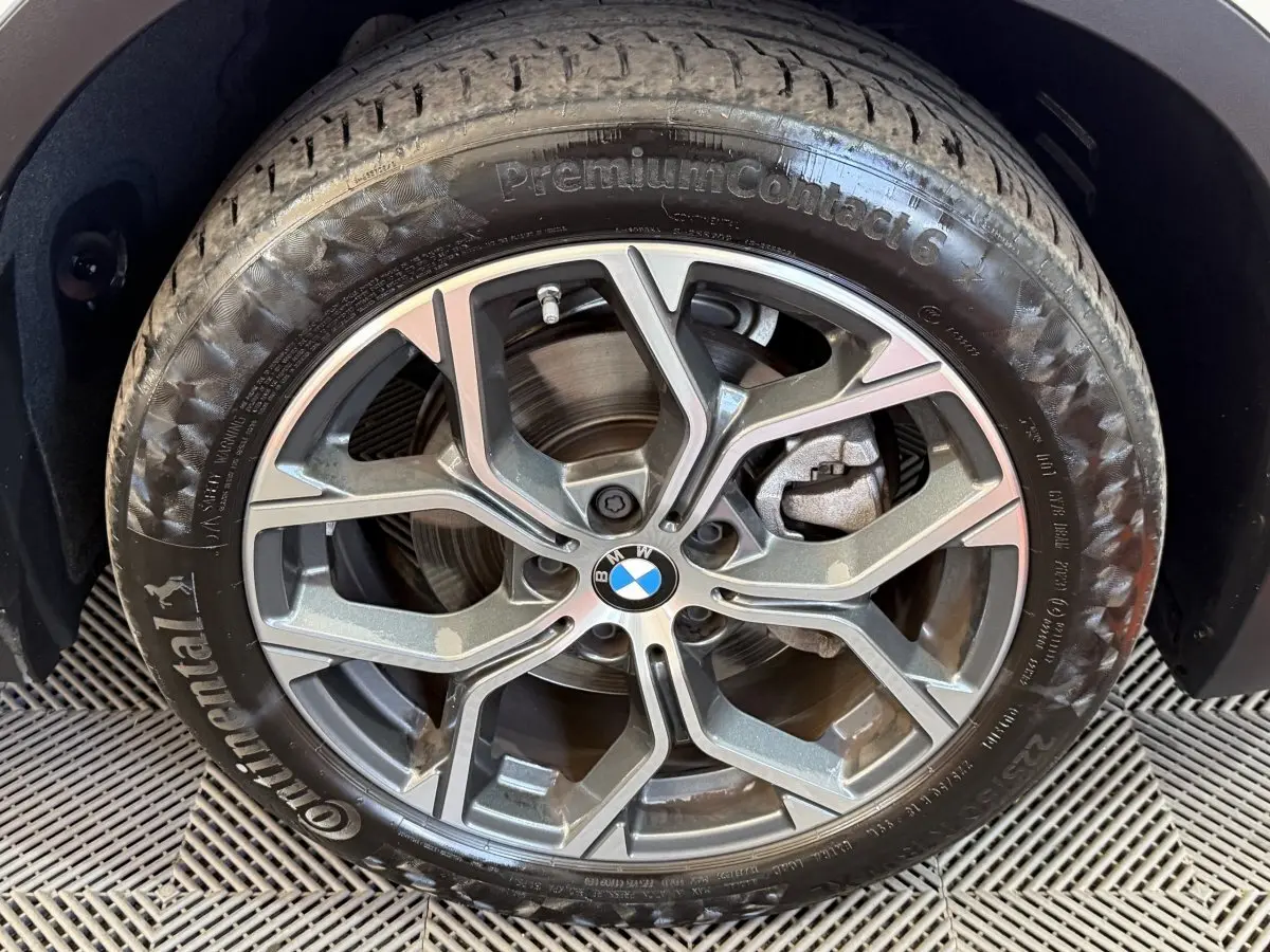 Gros plan sur la jante alliage grise avec logo BMW au centre, montée sur pneu Continental PremiumContact 6.