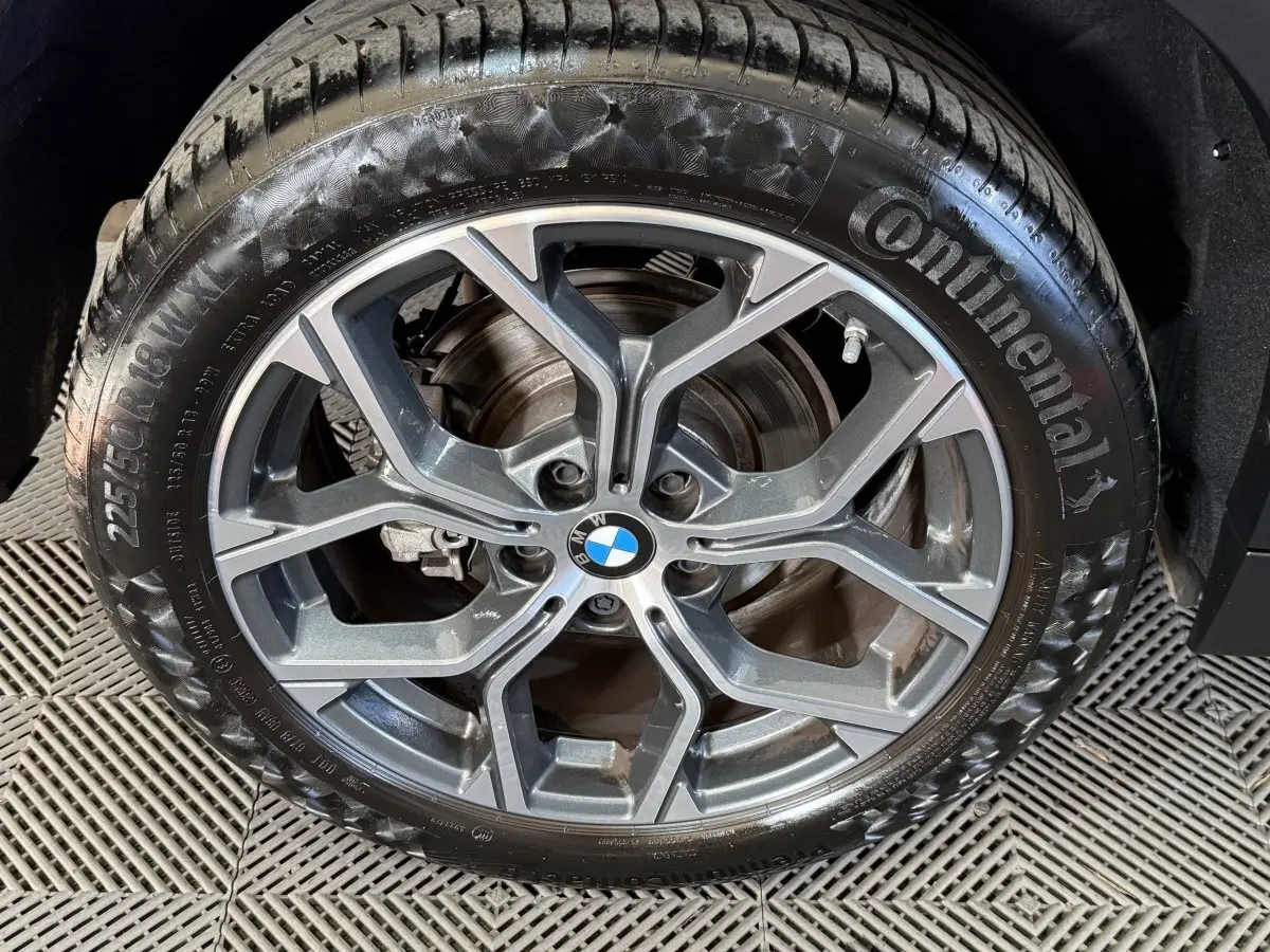 Gros plan sur la jante alliage grise et le pneu Continental du BMW X2 sDrive18i Lounge blanc, roue avant droite.
