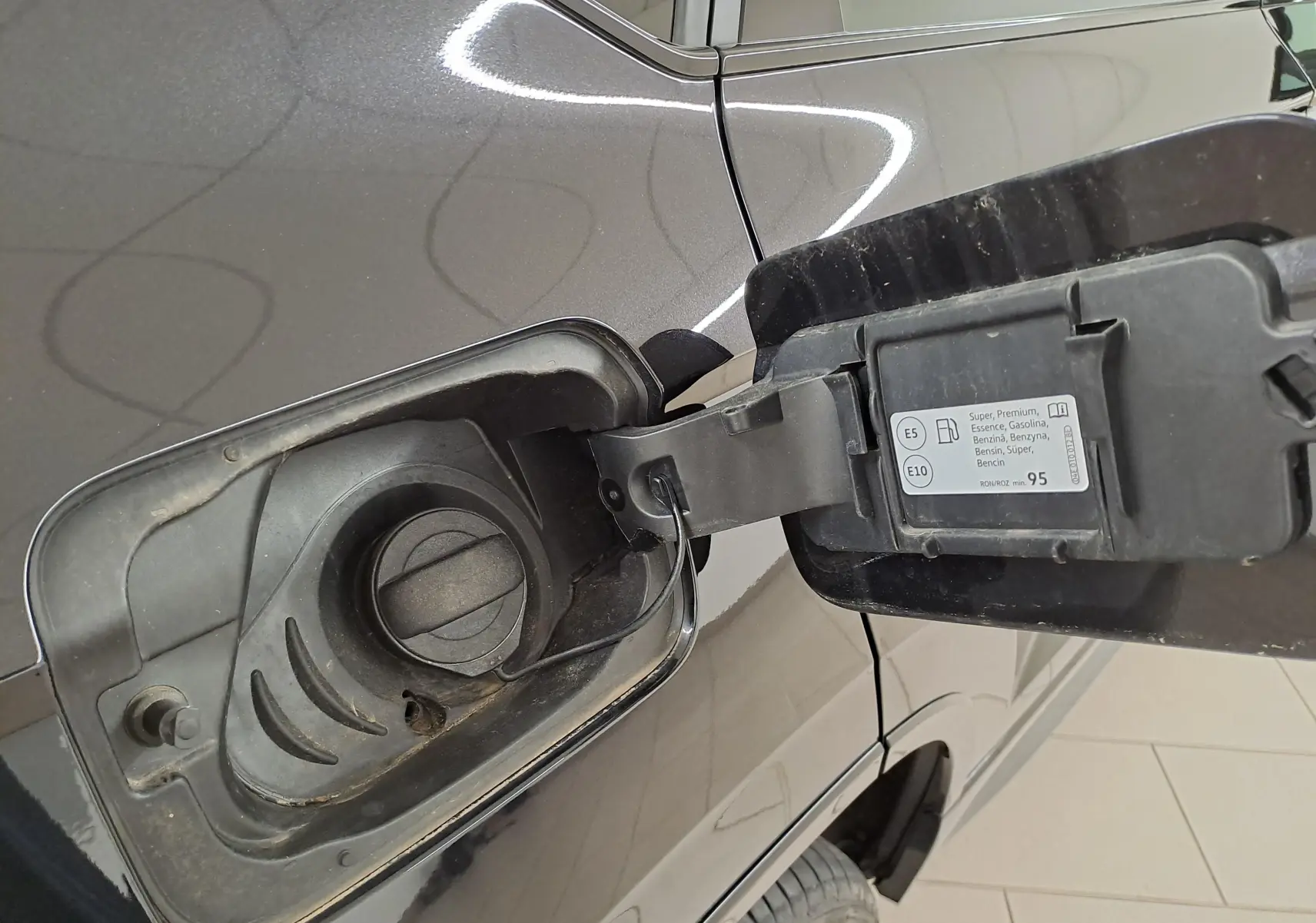 Gros plan sur la trappe à carburant ouverte côté gauche d’un CUPRA Ateca Noir Magique 2024, essence E5/E10.