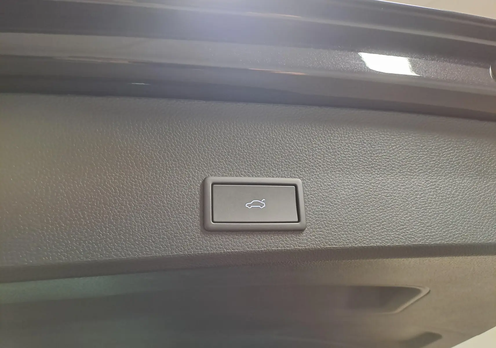 Bouton d'ouverture électrique du coffre sur la trappe intérieure d'un CUPRA Ateca Noir Magique 2024.