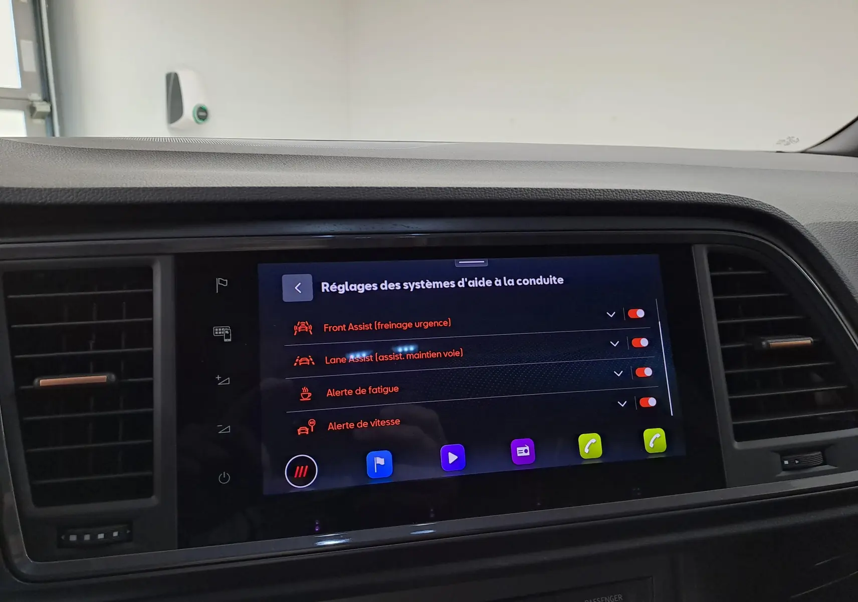 Écran central tactile du tableau de bord du CUPRA Ateca 2024 en mode réglages des aides à la conduite, intérieur noir.
