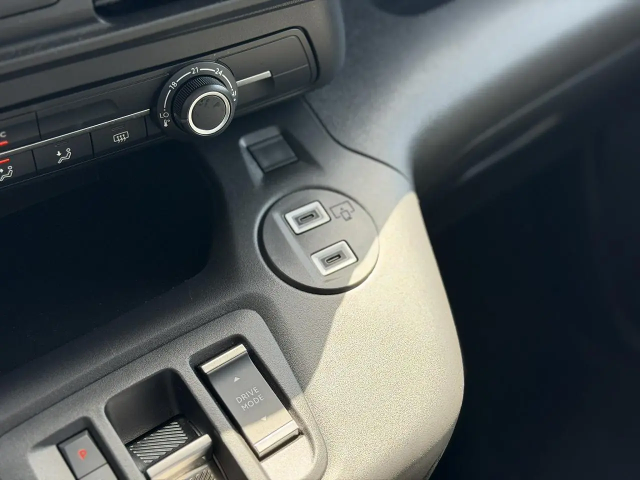 Détail de la console centrale grise du Citroën Berlingo ë-136, avec commandes Drive Mode et ports USB visibles.