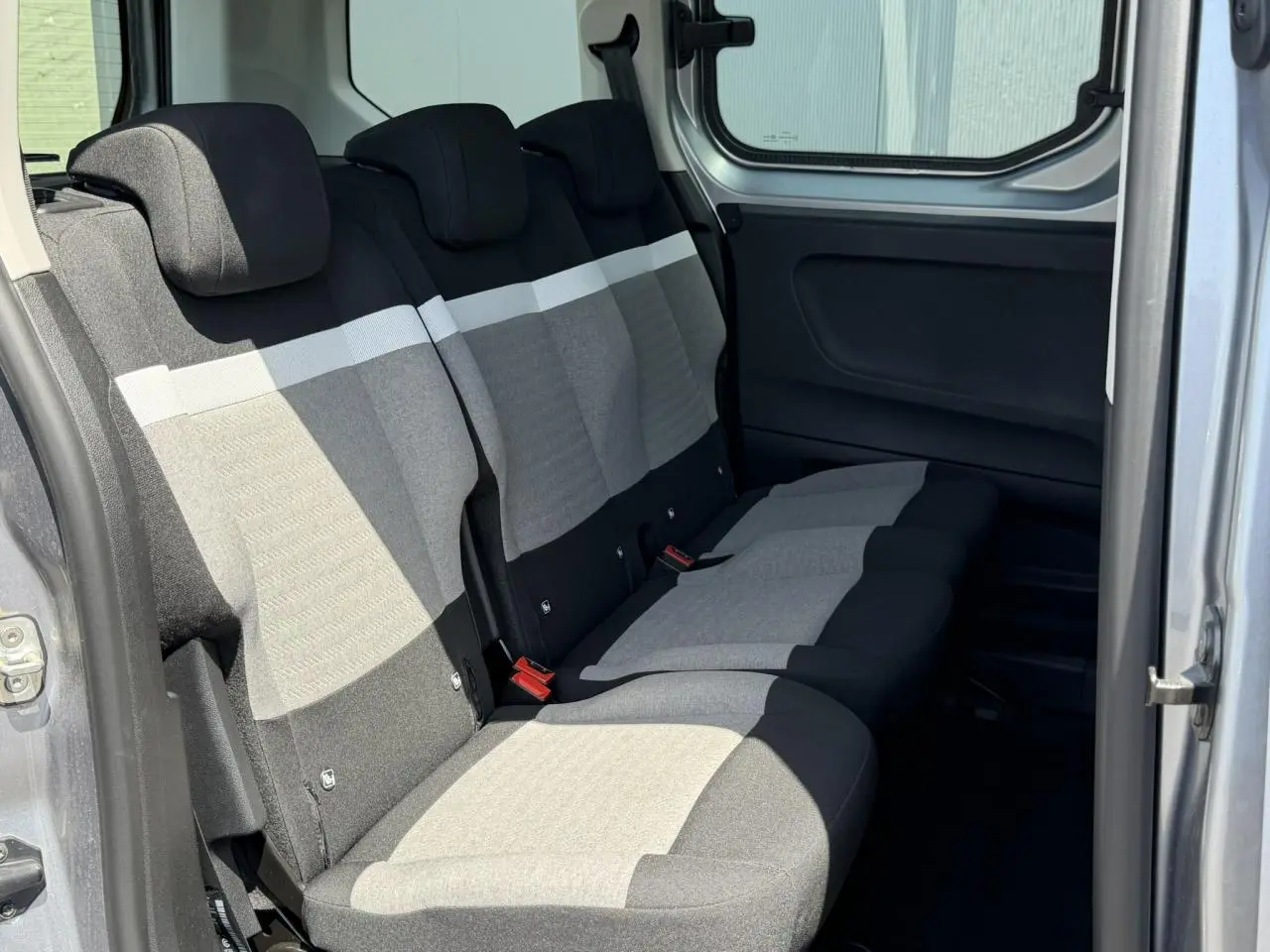 Vue intérieure côté droit sur la banquette arrière 3 places gris clair et foncé du Citroën Berlingo ë-136 2025.
