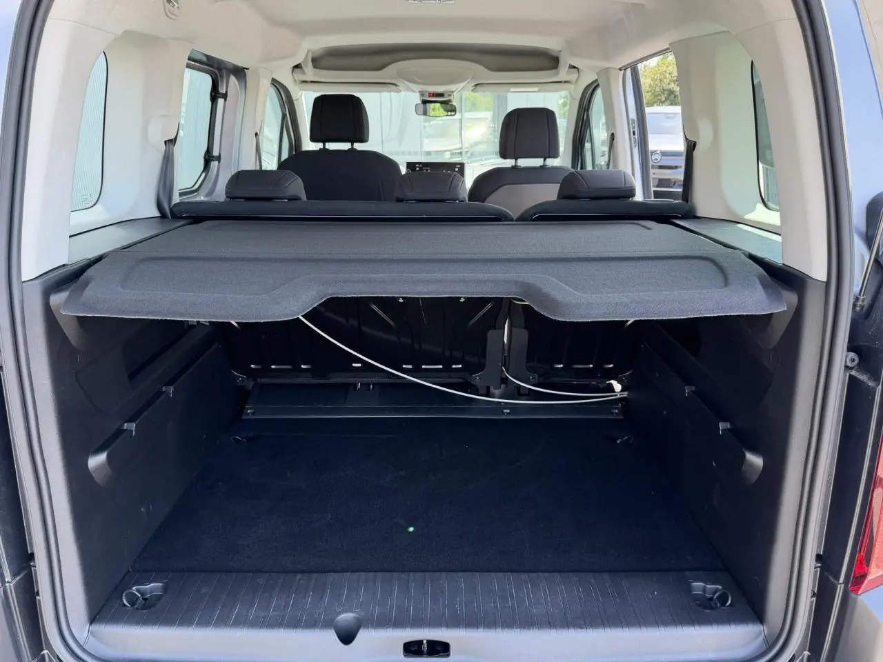 Vue arrière du coffre du Citroën Berlingo gris Artense avec tablette cache-bagages et sièges arrière visibles.