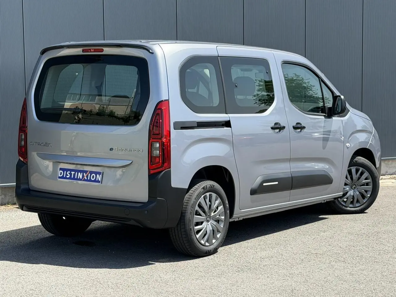 Vue 3/4 arrière droite du Citroën Berlingo électrique gris Artense avec porte coulissante et jantes tôles 16 pouces.