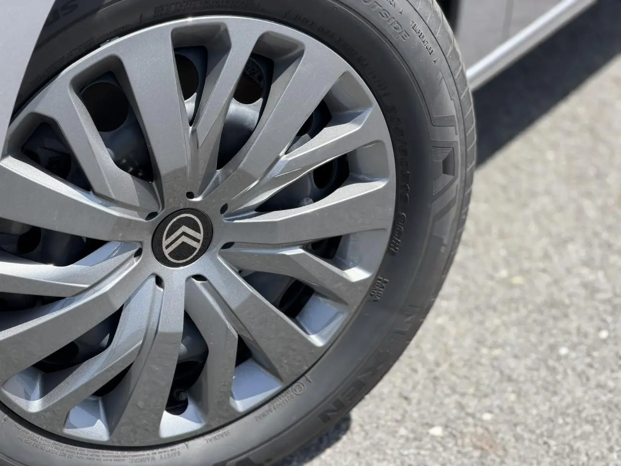 Gros plan sur la jante tôlée 16 pouces gris Artense du Citroën Berlingo ë-136 électrique, avec logo Citroën central.