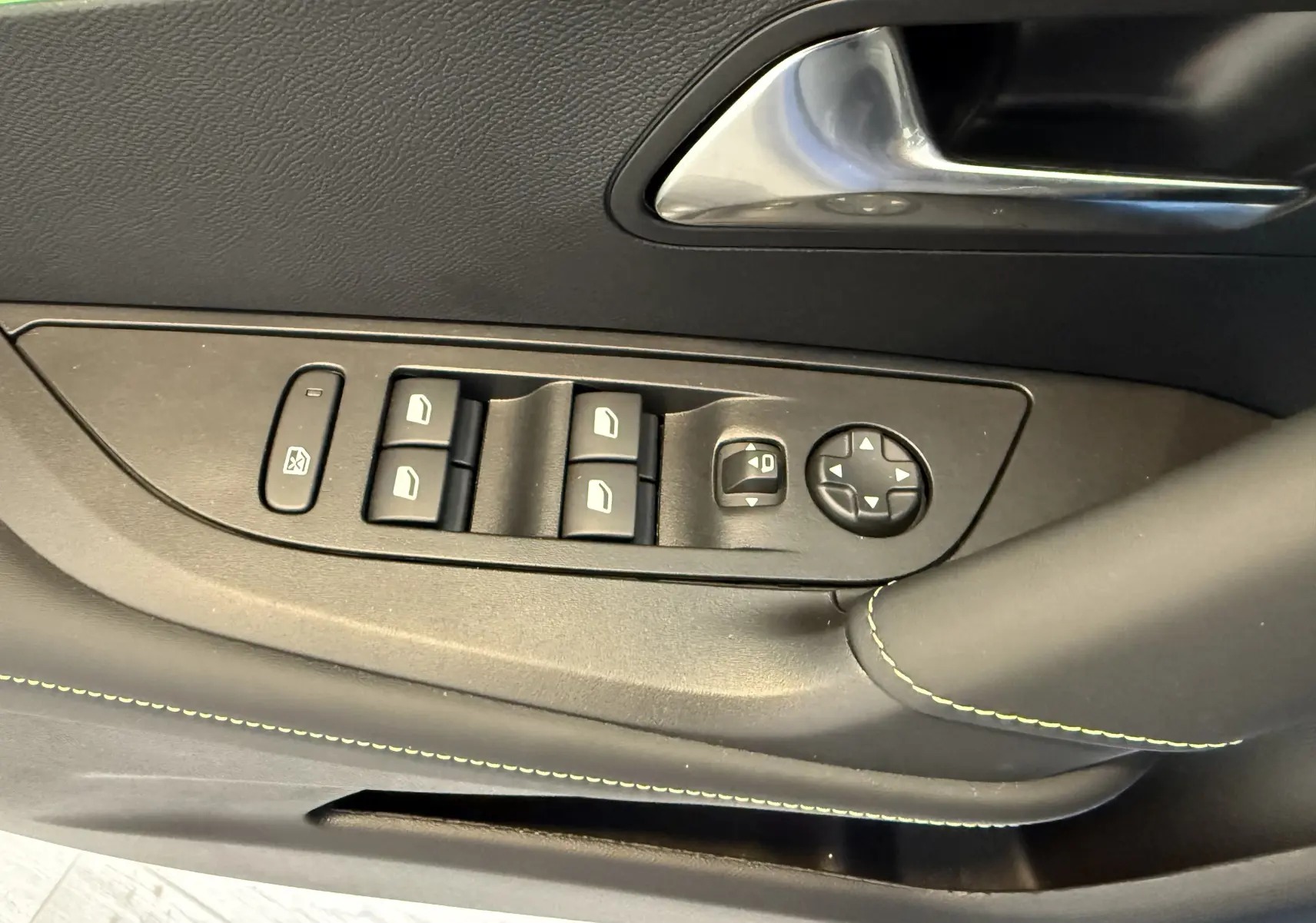Gros plan sur la commande des vitres et rétroviseurs côté gauche du PEUGEOT 2008 GT avec surpiqûres vertes sur la porte noire.