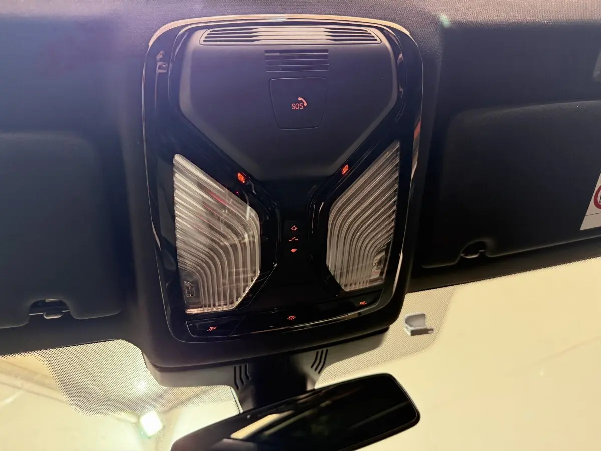 Plafonnier noir avec commandes éclairage et bouton SOS, vue intérieure avant du BMW Série 5 Touring 520d 2023.