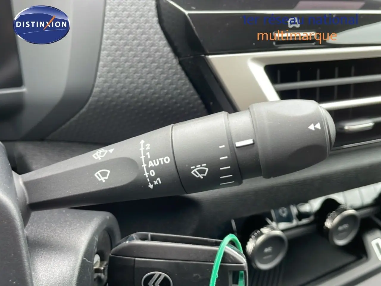 Gros plan sur la commande d’essuie-glace côté gauche dans l’habitacle noir d’une Citroën C4 blanc métal.