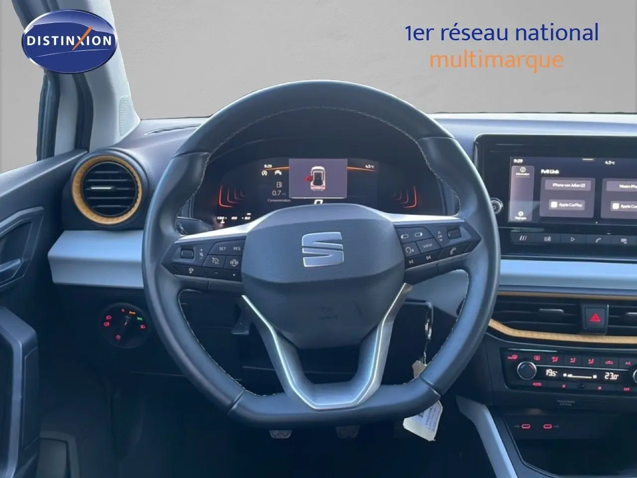 Vue intérieure centrée sur le volant cuir du SEAT Arona 2025, tableau de bord numérique et écran tactile visibles.
