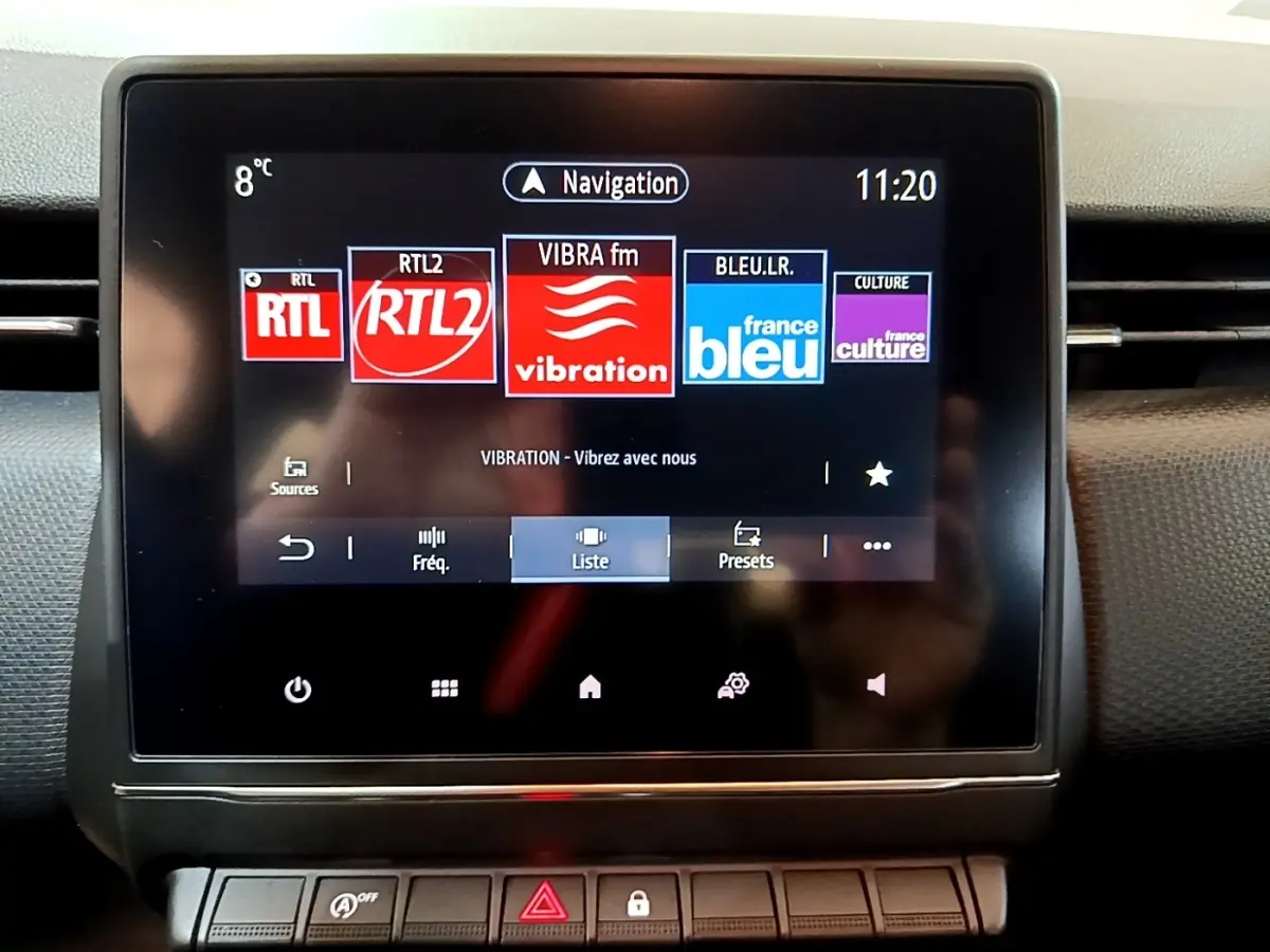 Écran tactile central de la Renault Clio Business blanc, affichant les stations radio avec interface moderne.