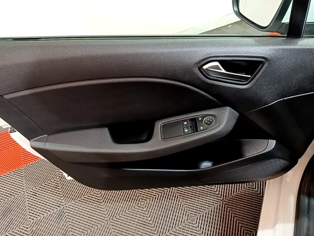 Vue intérieure du panneau de porte avant gauche noir d'une Renault Clio Business blanche, avec commandes électriques des vitres et rétroviseurs.