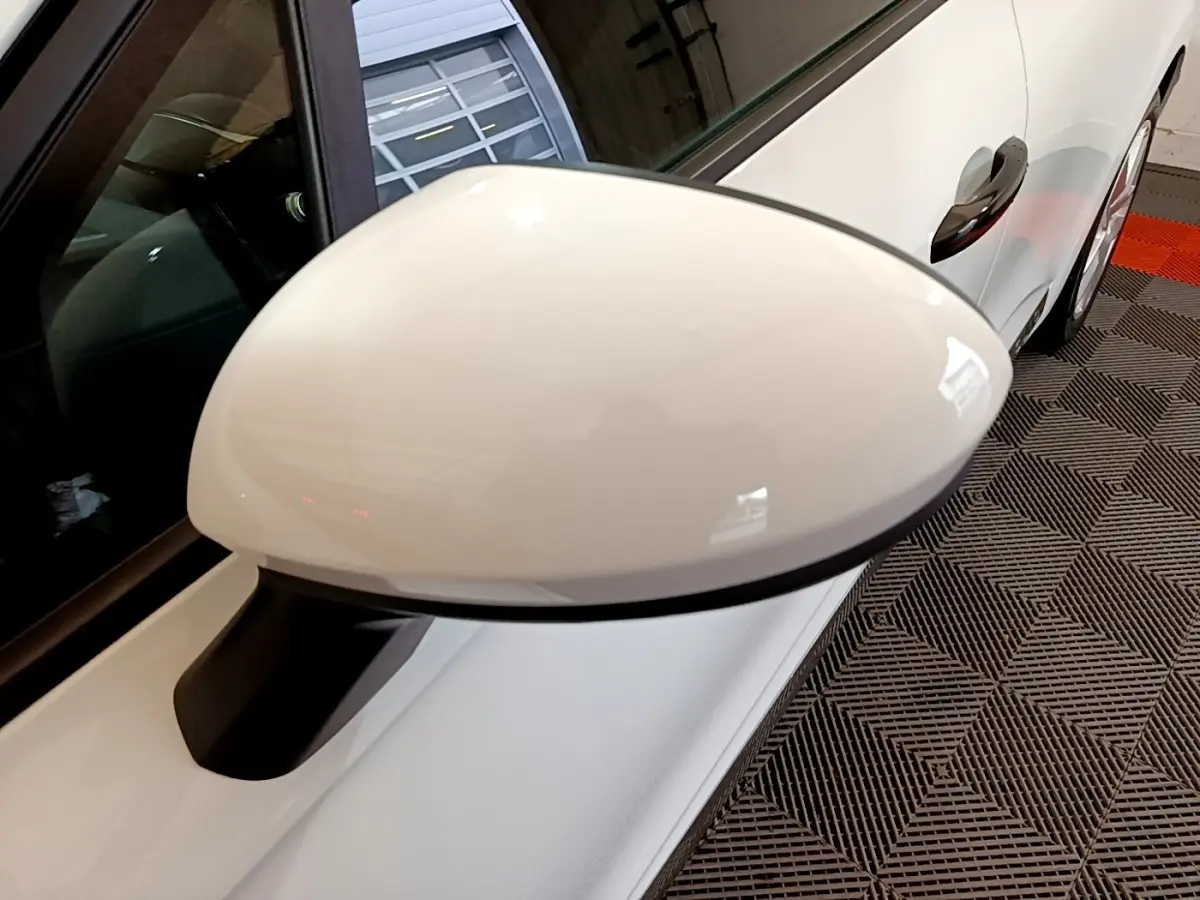 Rétroviseur côté gauche blanc de la Renault Clio Business 2021, avec porte et poignée visibles en arrière-plan.