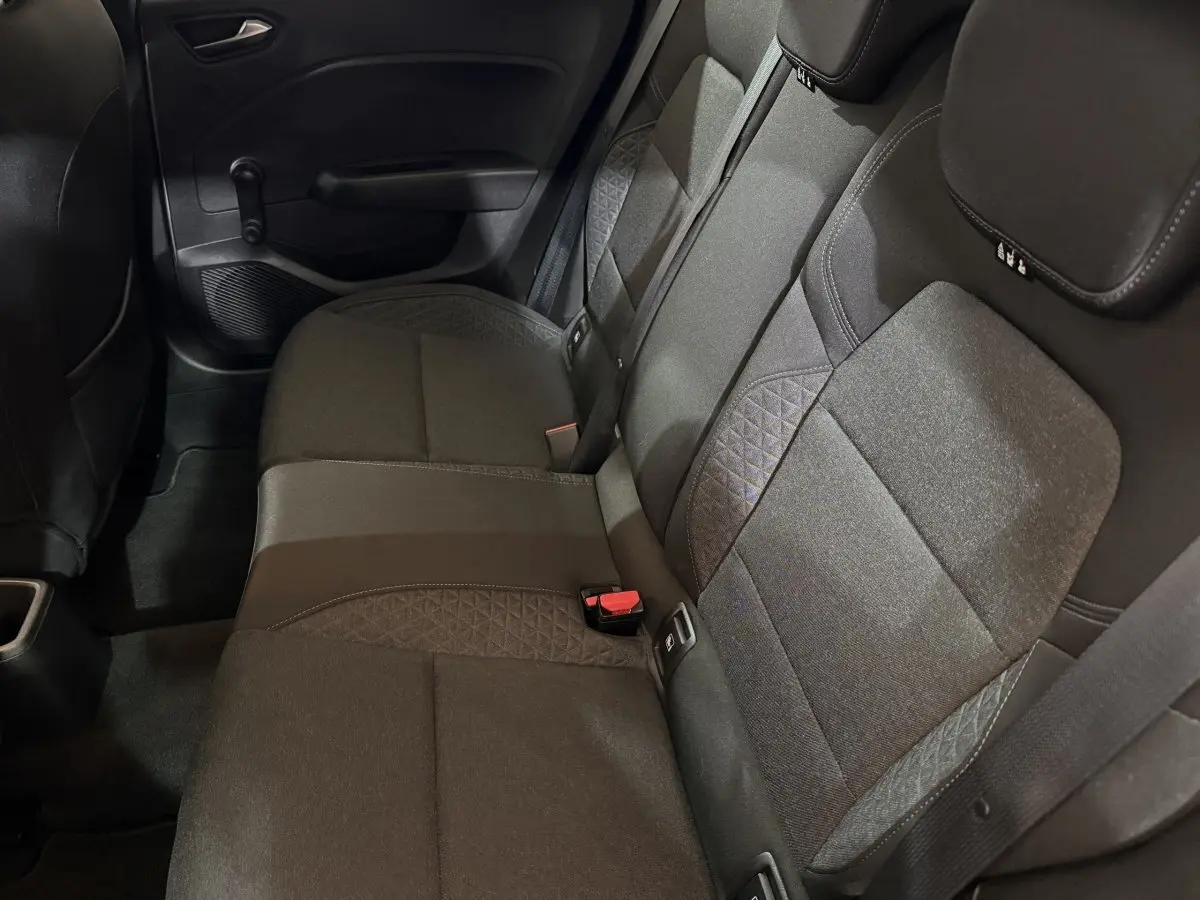Vue intérieure des sièges arrière gris foncé de la Renault Clio Business, montrant la banquette 3 places avec ceinture et appuie-têtes.