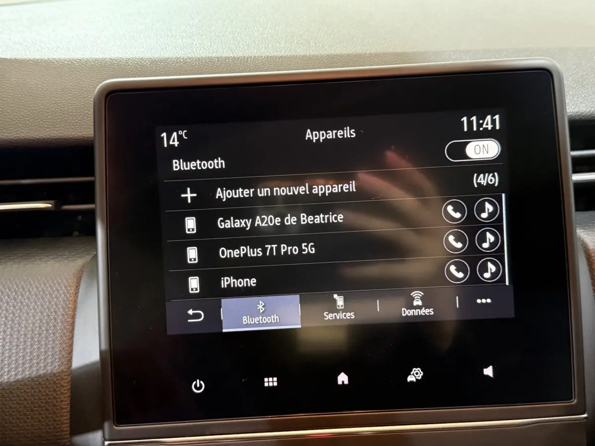 Écran tactile central de la Renault Clio Business blanc, affichant la connexion Bluetooth avec plusieurs appareils listés.