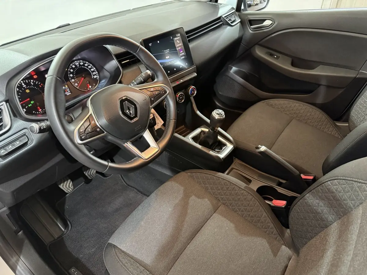 Vue intérieure côté conducteur de la Renault Clio Business 2020, volant cuir, tableau de bord avec écran tactile et boîte manuelle.