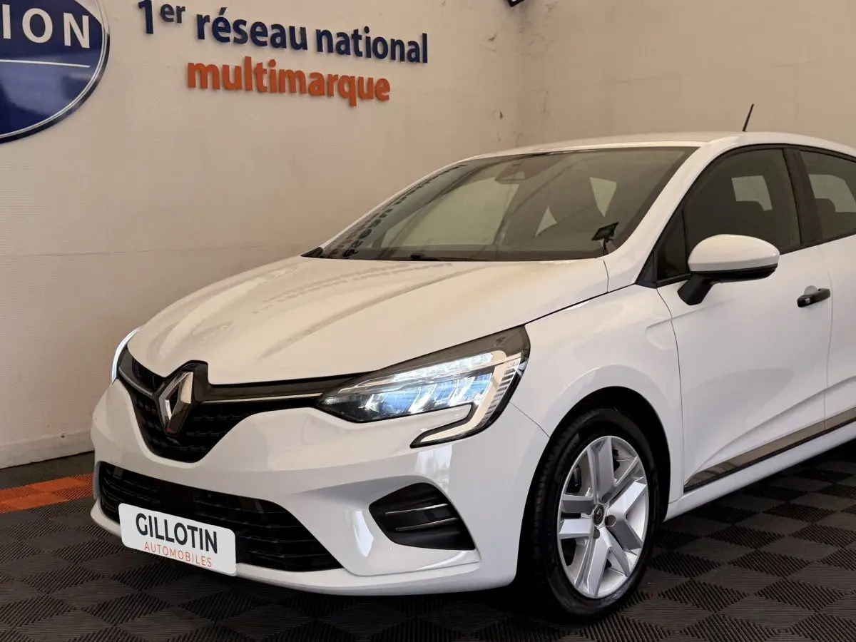 Renault Clio Business SCe 75 blanche vue 3/4 avant droit, avec phares LED allumés et jantes alliage.