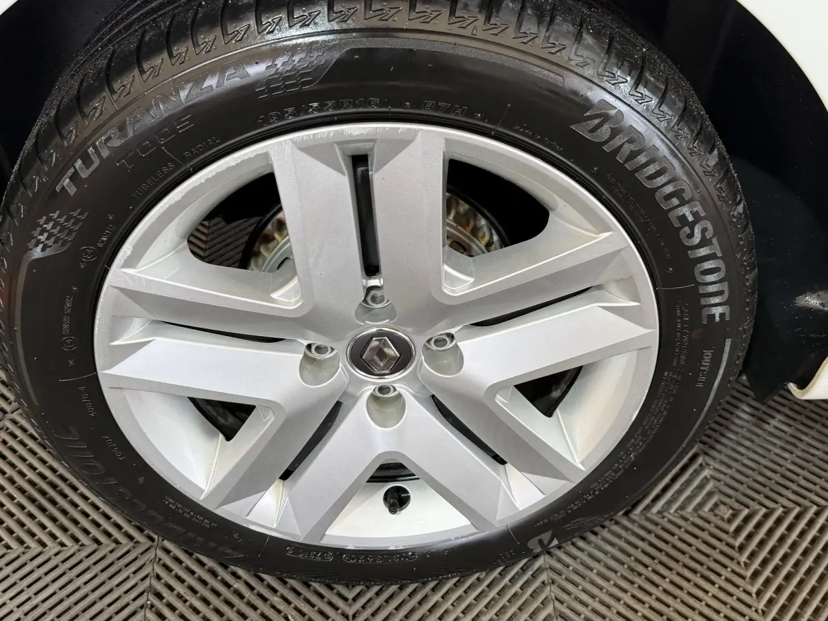 Gros plan sur la roue arrière droite d'une Renault Clio blanche de 2020 avec pneu Bridgestone visible.