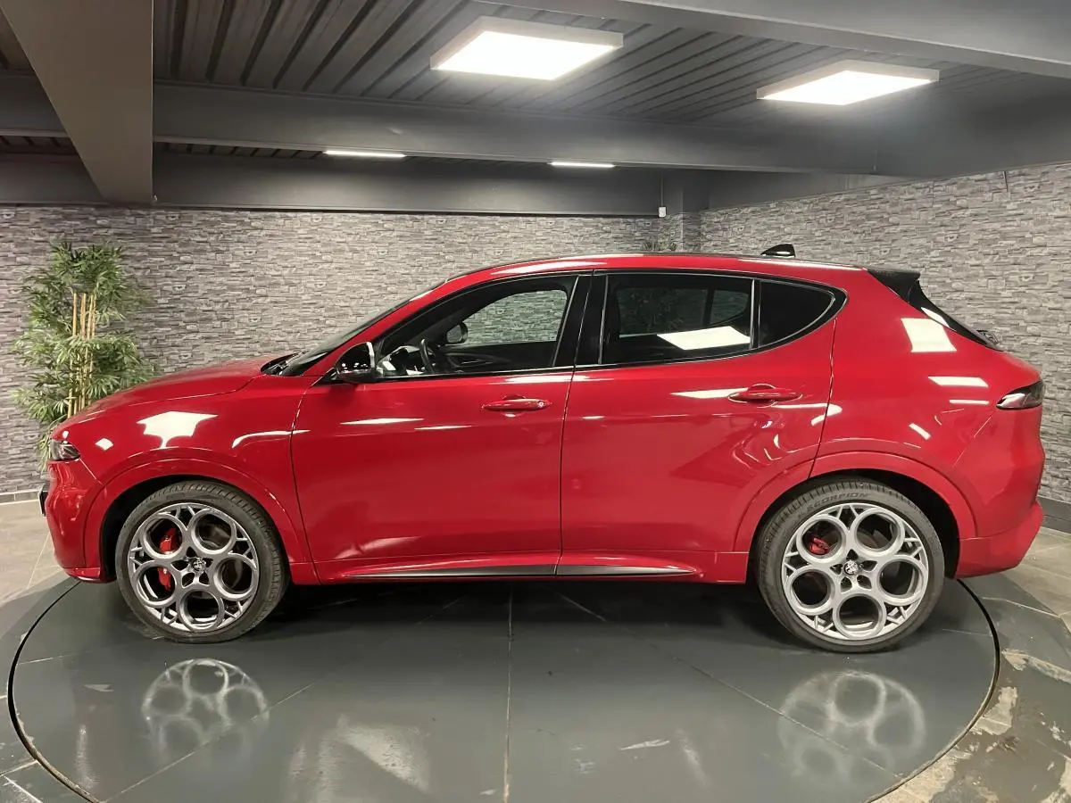 Alfa Romeo Tonale rouge vue de profil côté gauche, avec jantes alliage 20 pouces et étriers de frein rouges.