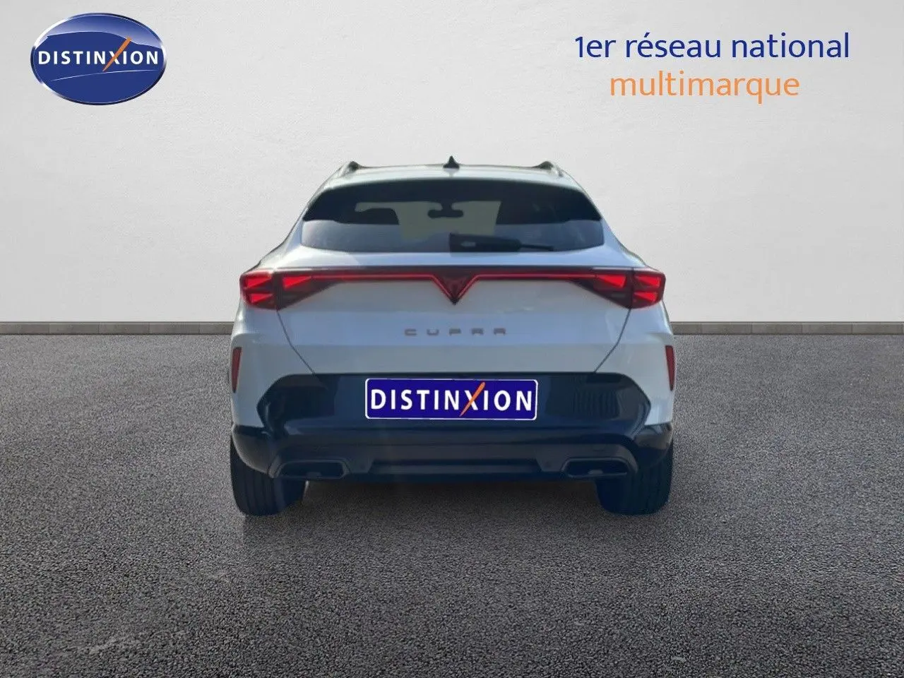 Vue arrière d'une CUPRA Formentor blanc neige métal 2025 avec feux LED reliés et double sortie d'échappement intégrée.