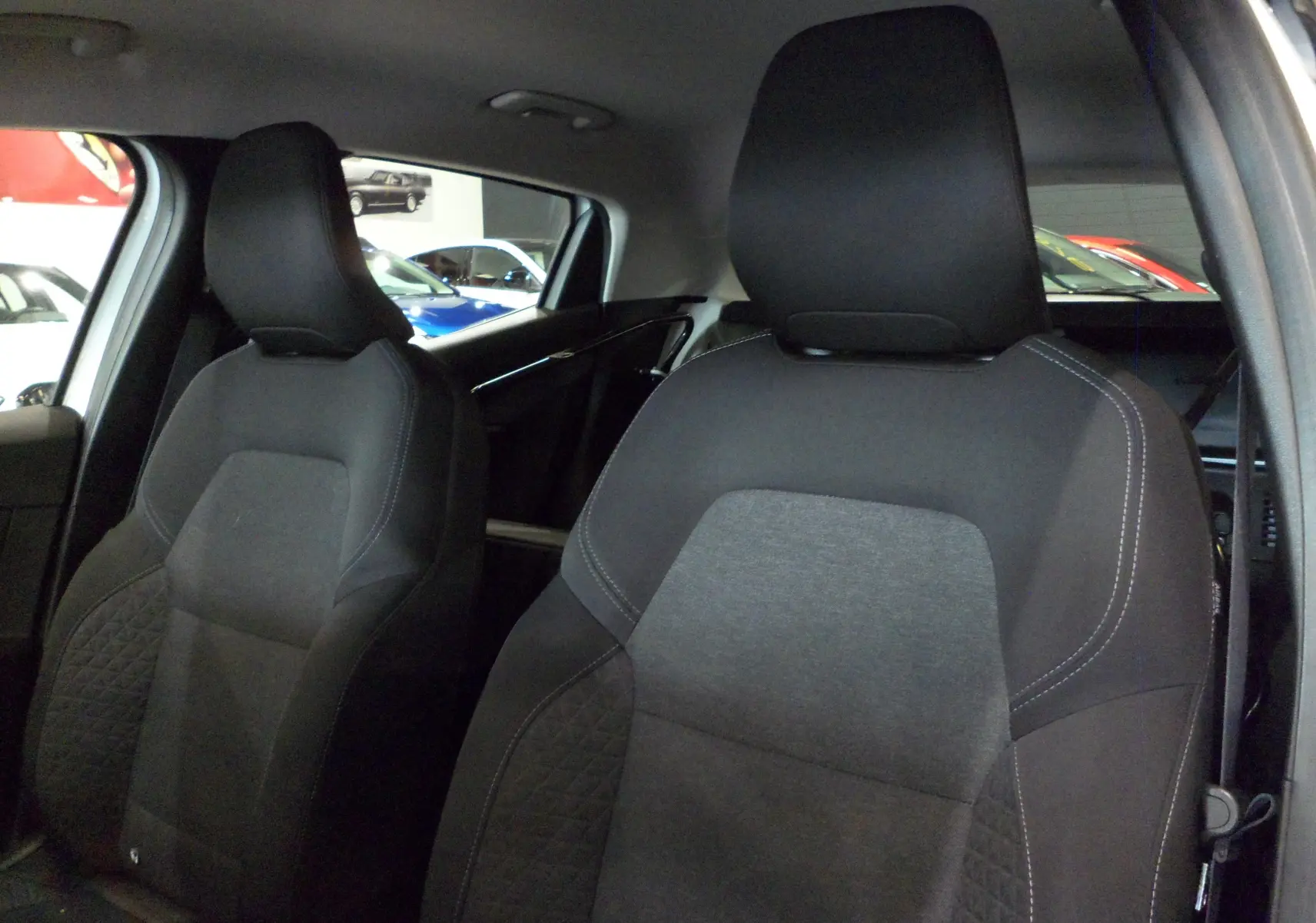 Gros plan sur les sièges avant en tissu gris et noir de la Renault Clio V blanche, version Société 2020.