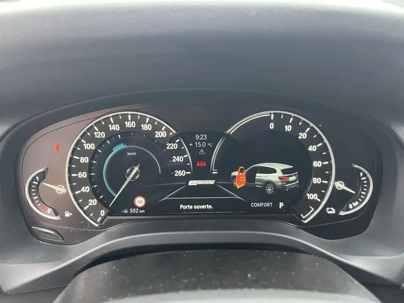 Vue rapprochée du tableau de bord numérique du BMW X3 xDrive30e 2020, affichant porte arrière ouverte et indicateurs de vitesse.