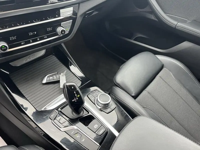 Vue intérieure côté droit du BMW X3 xDrive30e 2020, montrant la console centrale noire brillante avec levier de vitesses automatique et siège en tissu anthracite.
