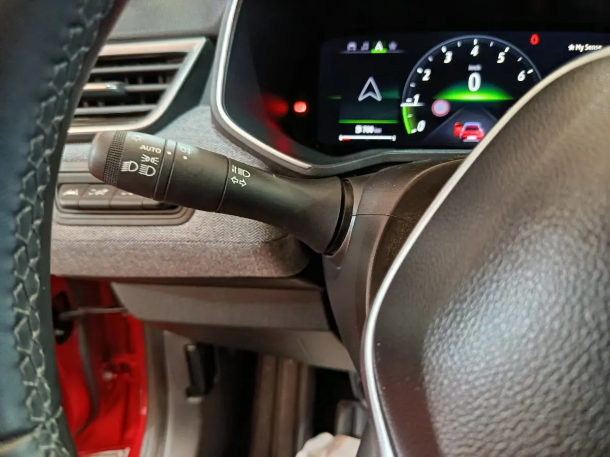 Détail du combiné d'instruments numérique et du commodo gauche du volant dans une Renault Clio Techno TCe 90 rouge 2024.